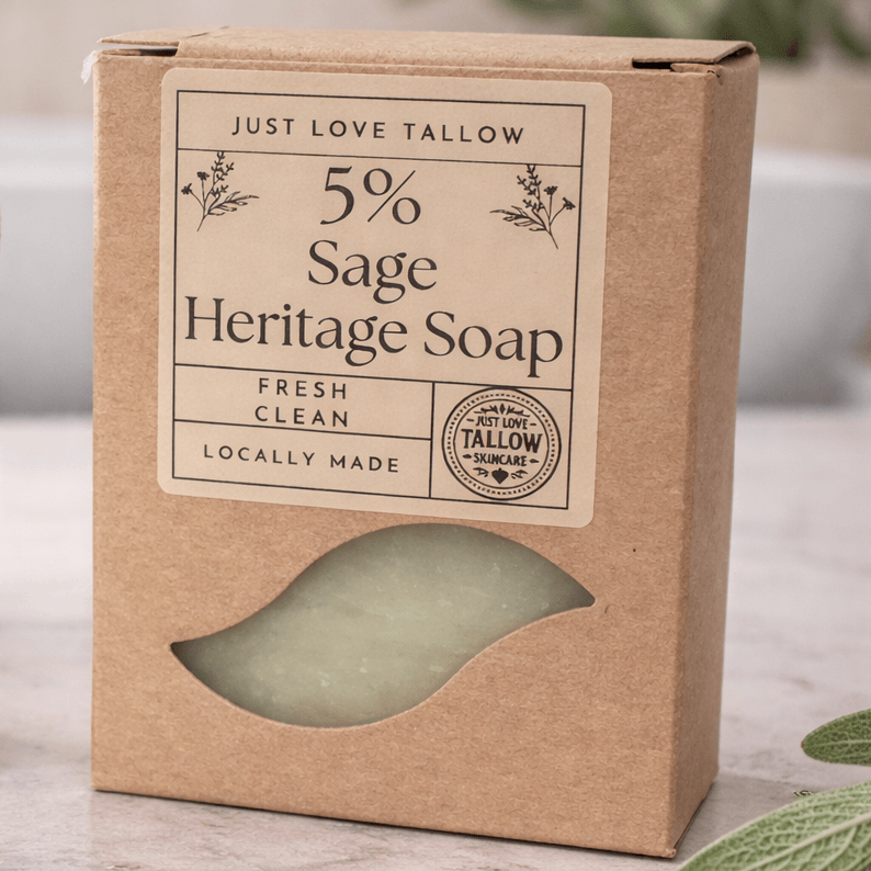 Bar of soap on a wooden soap dish with leaves and towels in the background