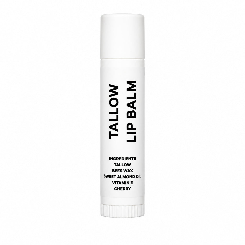 A single white tube of Tallow Lip Balm with black text, standing upright on a wrinkled light gray fabric background.