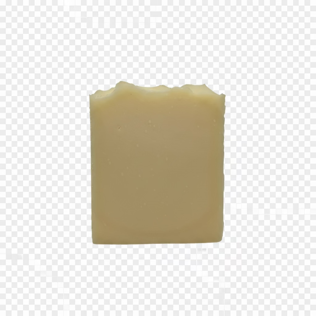 A single rectangular bar of pale yellow soap with a rustic, unevenly chipped top, standing upright on a white fabric background.