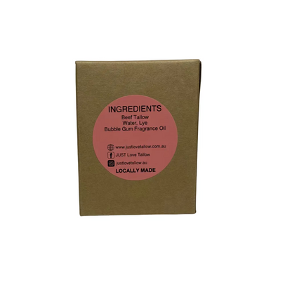 A square brown kraft paper box with a circular pink label on the front reading 'INGREDIENTS Beef Tallow Water Lye Bubble Gum Fragrance Oil' and 'JUST Low Tallow' with website and social details, photographed against a white fabric backdrop.