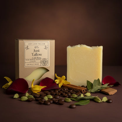 A bar of pale yellow soap next to its kraft paper packaging box, labeled 'Just Tallow' by 'Just Love Tallow', set against a light gray fabric backdrop.